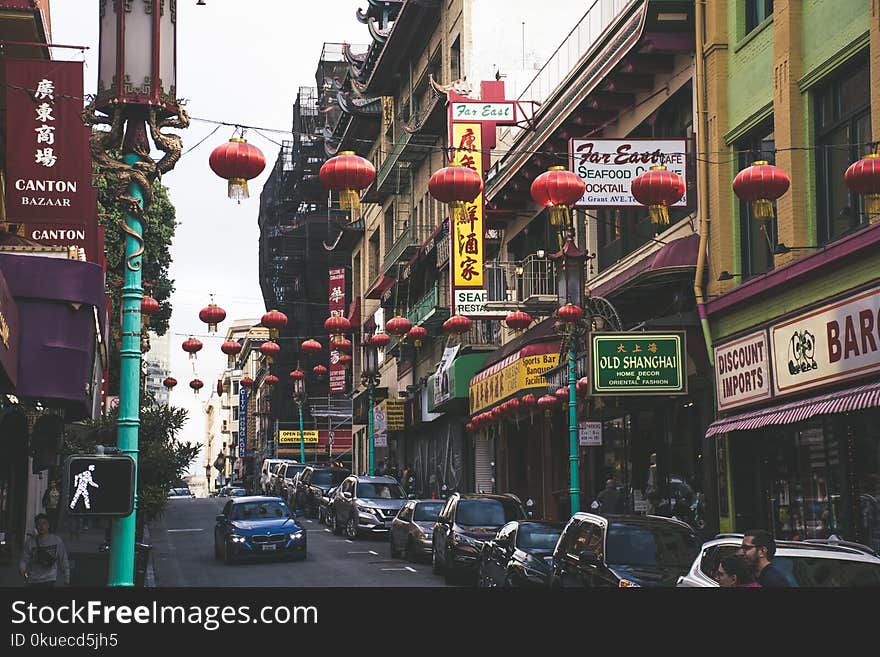 Vehicles Parked Beside Buildings Under Red Chinese Lanterns