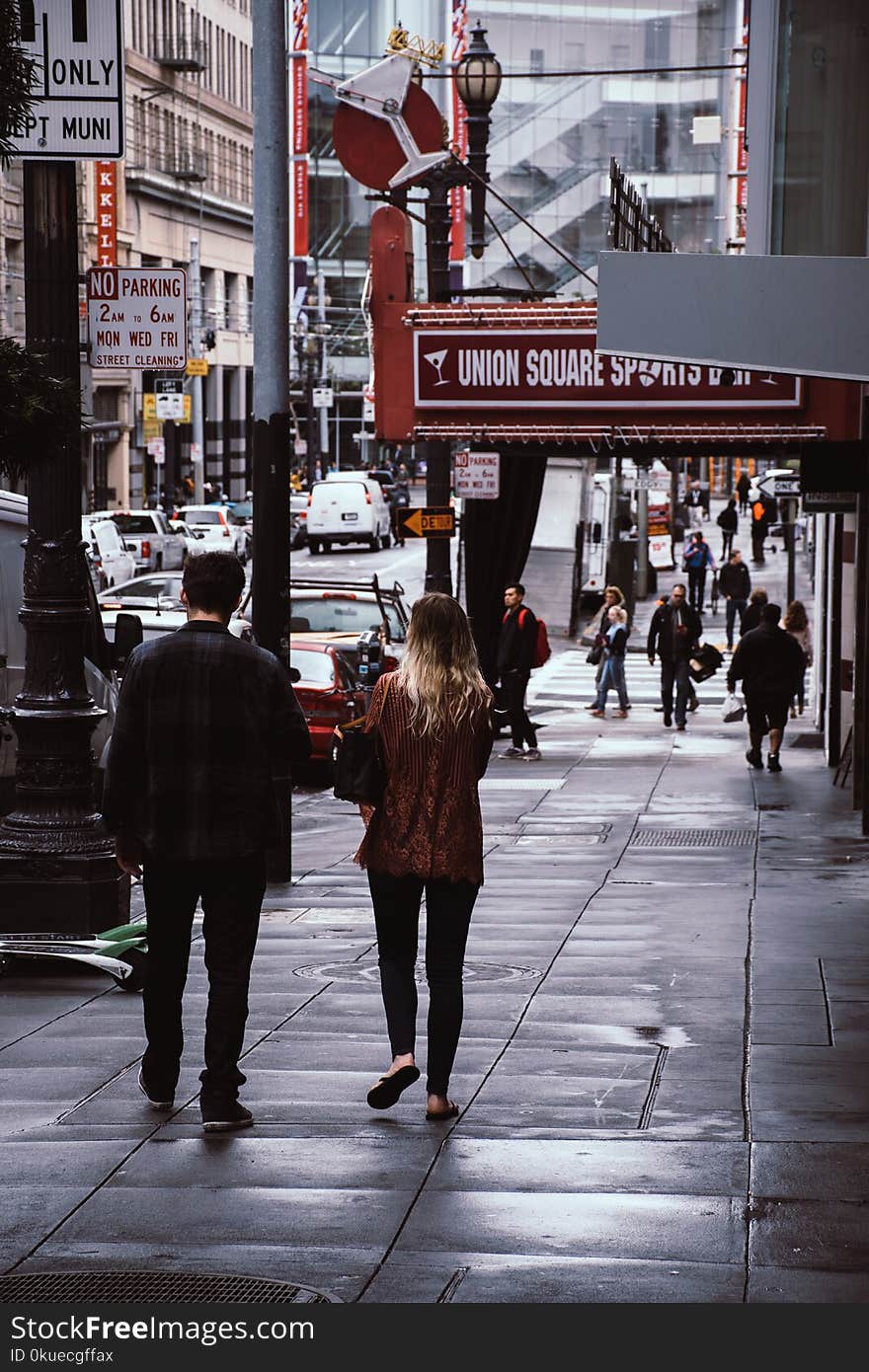 Man and Woman Walk Beside Store