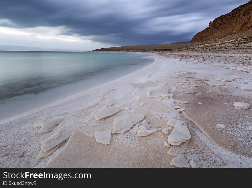 Body of Water Beside Mountain