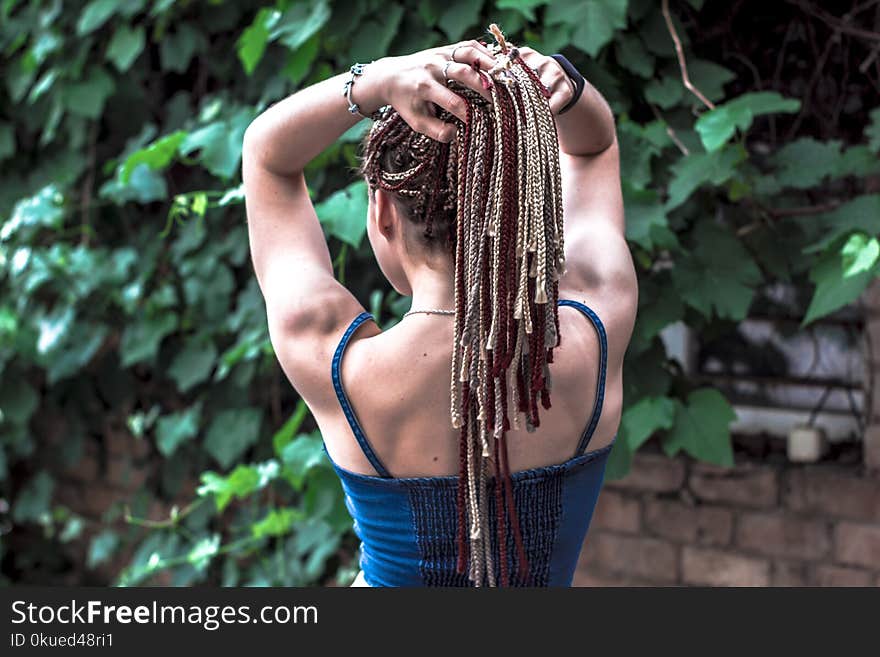 Woman Facing Brown Brick Wall