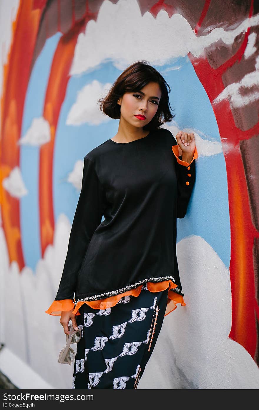 Woman Wearing Black Long-sleeved Shirt Learning on Wall