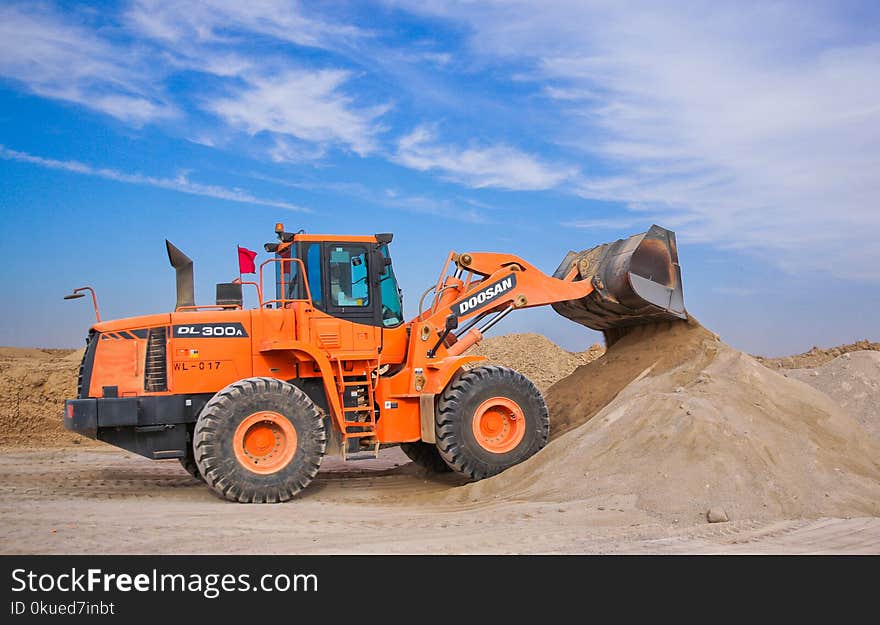 Orange Excavator on Brown Hill