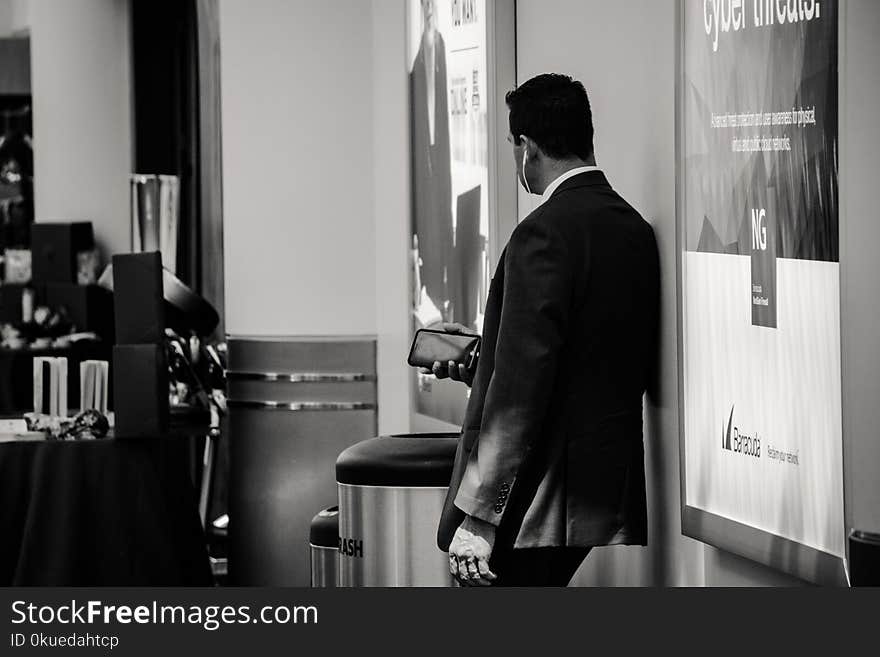 Man in Suit Jacket Near Poster