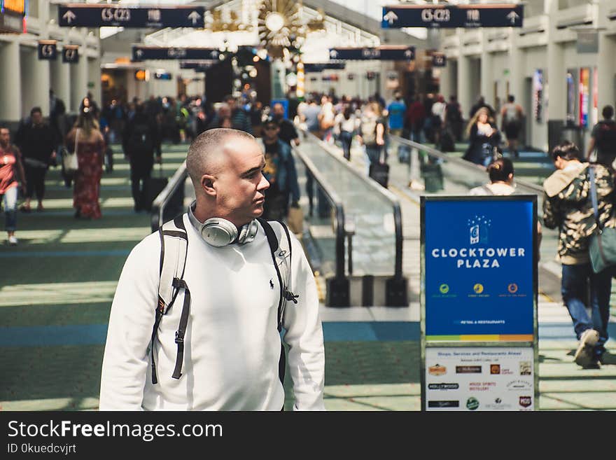 Man Walking Near Clocktower Plaza Signage