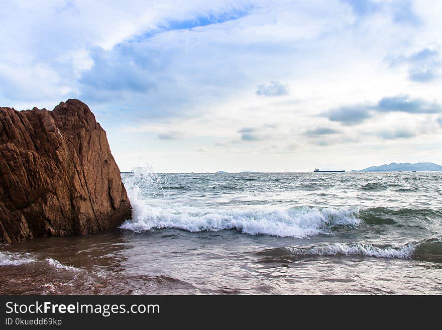 Sea Waves Splashing on Shore and Rock Island