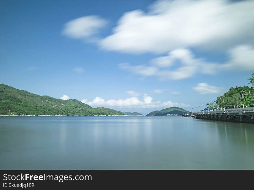 Body of Water Under White Clouds