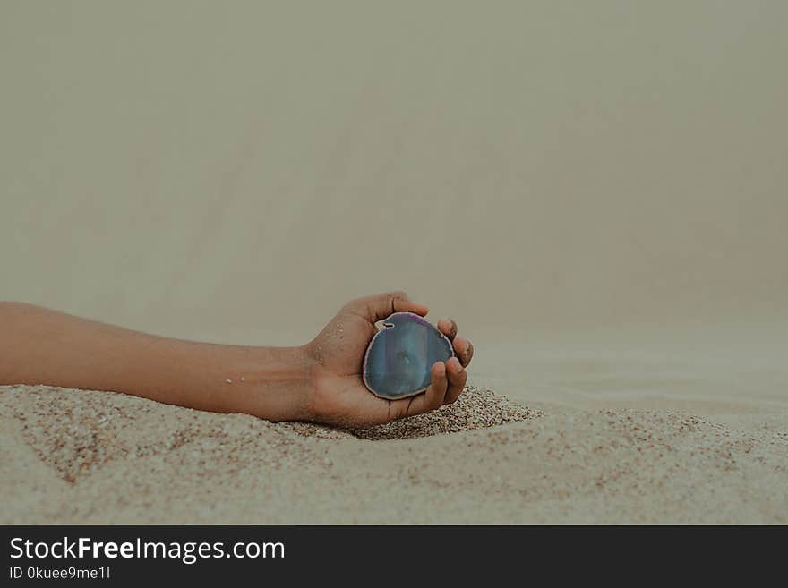 Person Holding Gemstone on Seashore