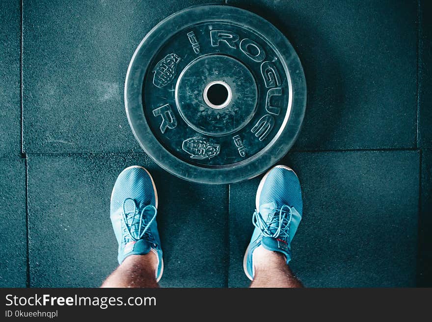 Black Steel Gym Plate and Pair of Blue Running Shoes