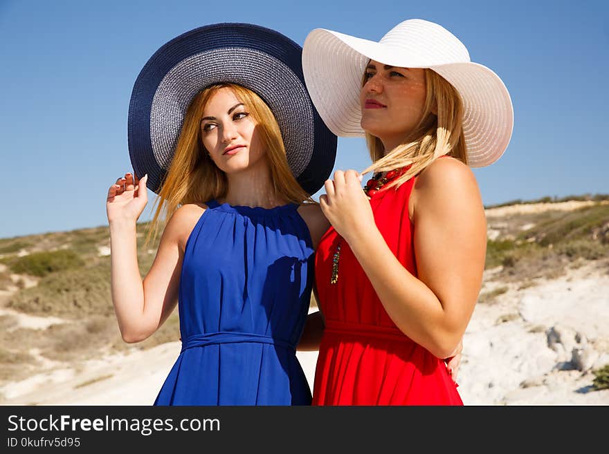 Blond women in the red and blue dresses at the beach in Cyprus.