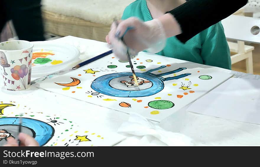 Children boys sitting together around the table in classroom and drawing. With them is their young and beautiful teacher.. 4k