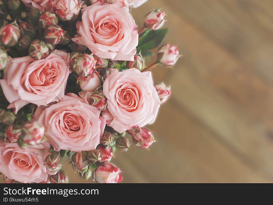 Pink roses bouquet over wooden table. Top view with copy space. Toned. Pink roses bouquet over wooden table. Top view with copy space. Toned