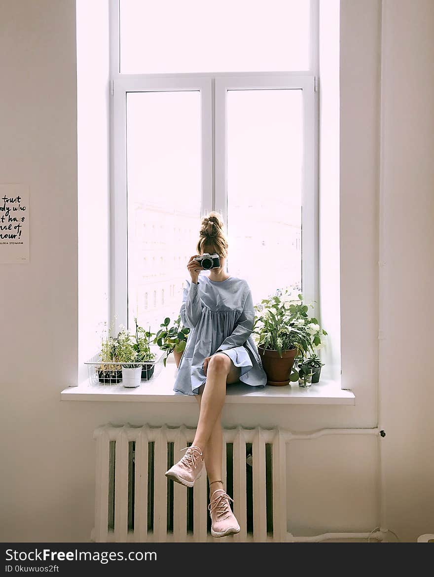 Woman in Grey Long-sleeved Dress Sitting on Window