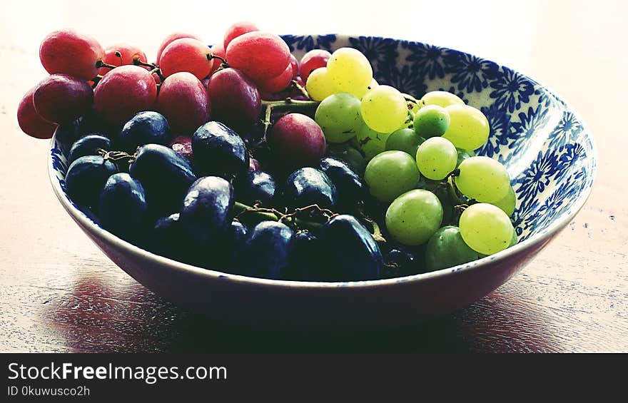 Red, Black, and Green Grapes in Round Blue and White Floral Ceramic Bowl