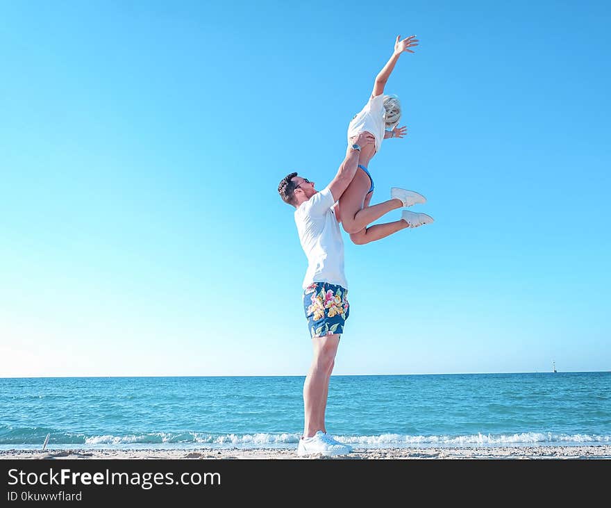 Man Holding Woman Near the Sea