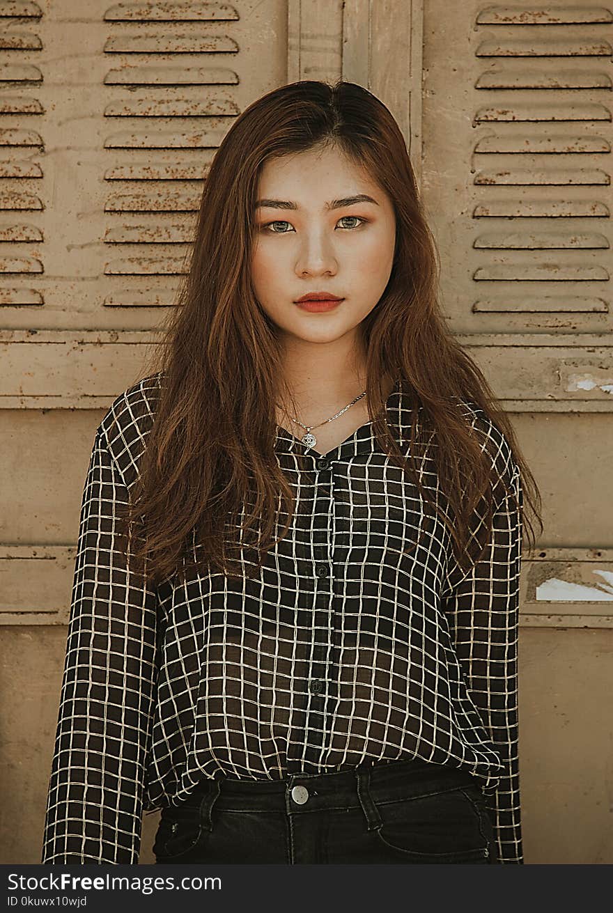 Woman Wearing White and Black Tattersall Collared Button-up Blouse Standing Near Brown Wall