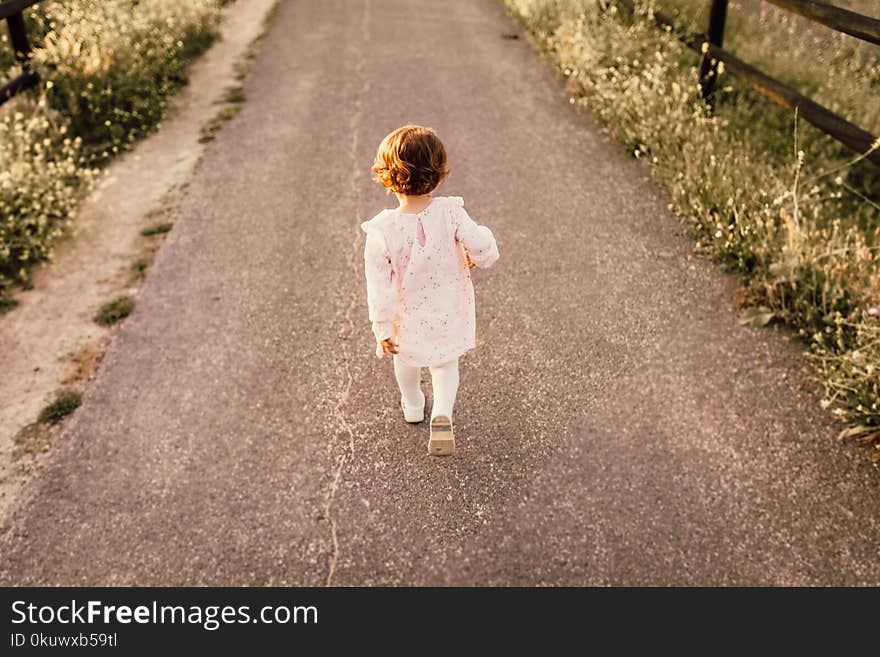 Girl Wearing White Clothes Walking on Pavement Road