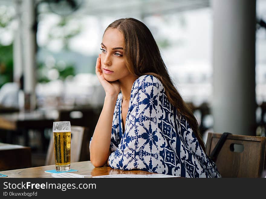 Woman in White and Blue Top Sitting in Front Table