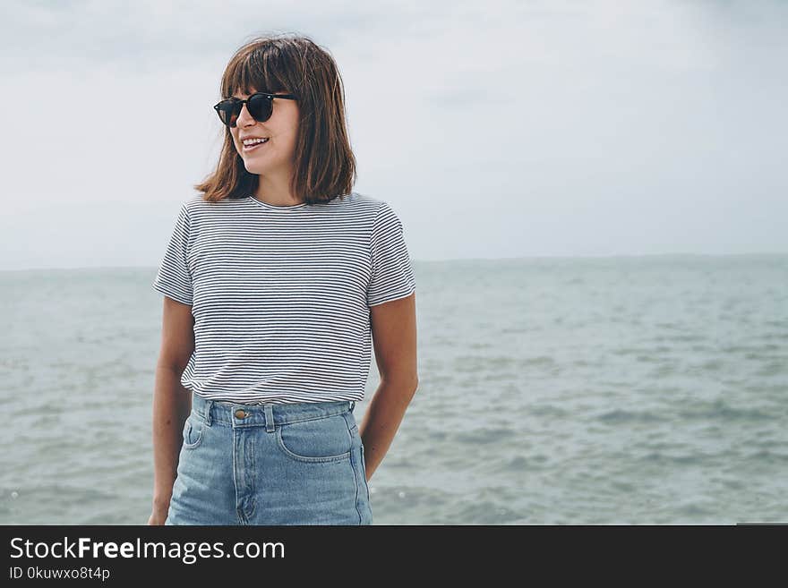 Woman Standing Near Sea While Wearing Black Frame Sunglasses