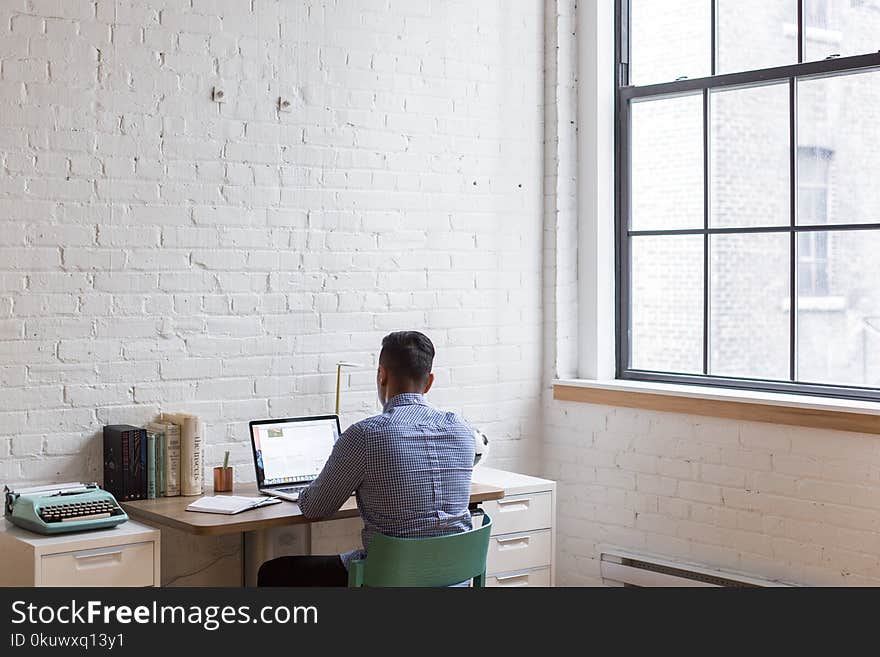 Man Sitting Down and Using His Laptop