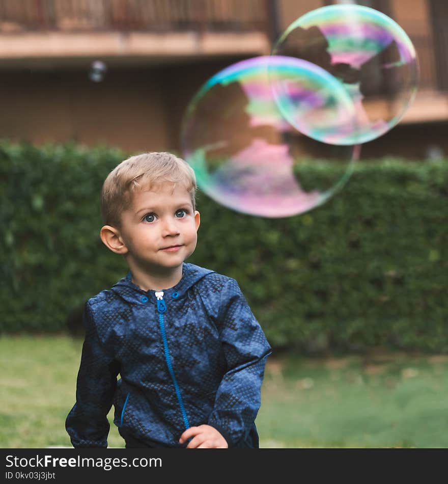 Beautiful baby boy enjoying blowing big soap bubbles in the autumn. Happy childhood concept. Beautiful baby boy enjoying blowing big soap bubbles in the autumn. Happy childhood concept.