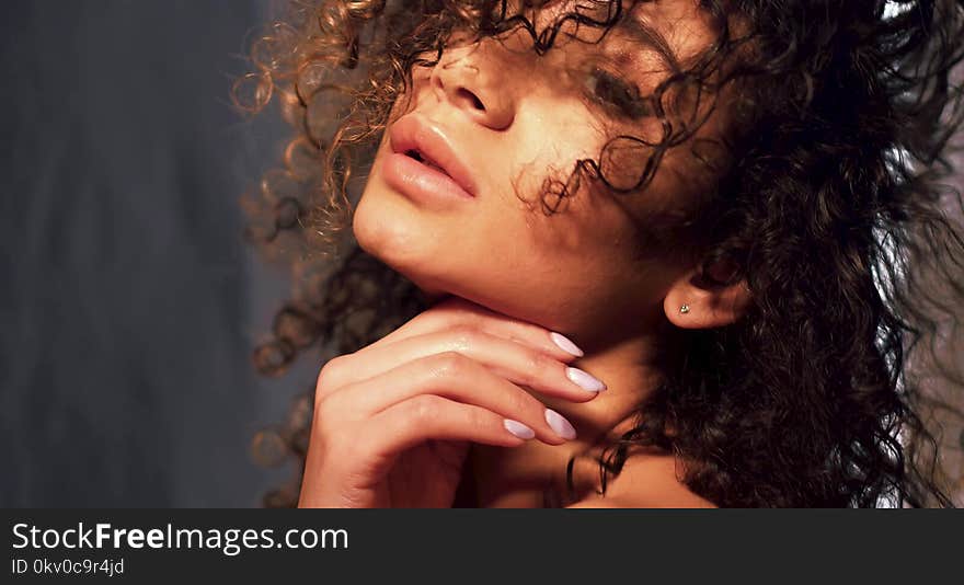 Face image of swarthy beautiful model with curly hair and cared skin. Beauty concept. Face image of swarthy beautiful model with curly hair and cared skin. Beauty concept.