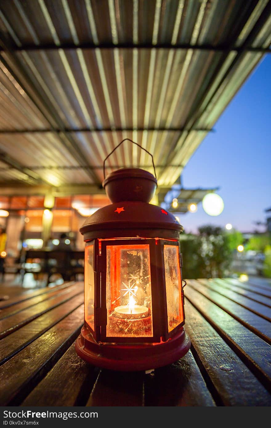 Abstract candle lantern light on wood table in blur bokeh pub re