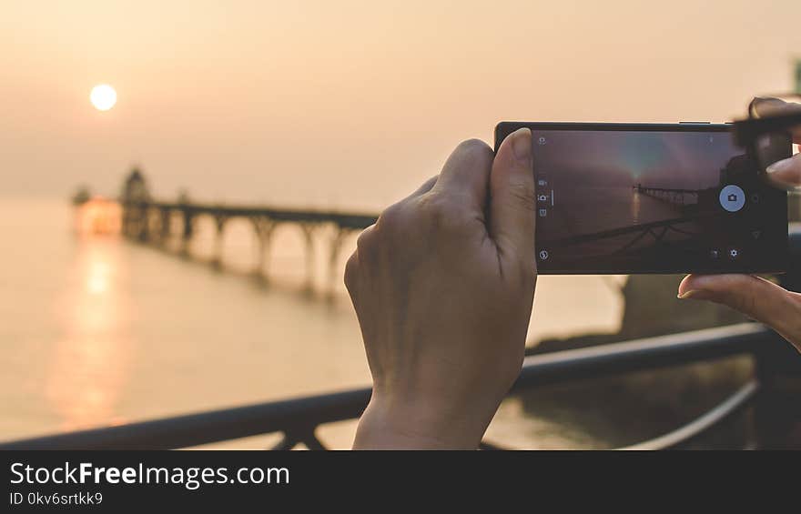 Female Photographing Sunset with Mobile Phone