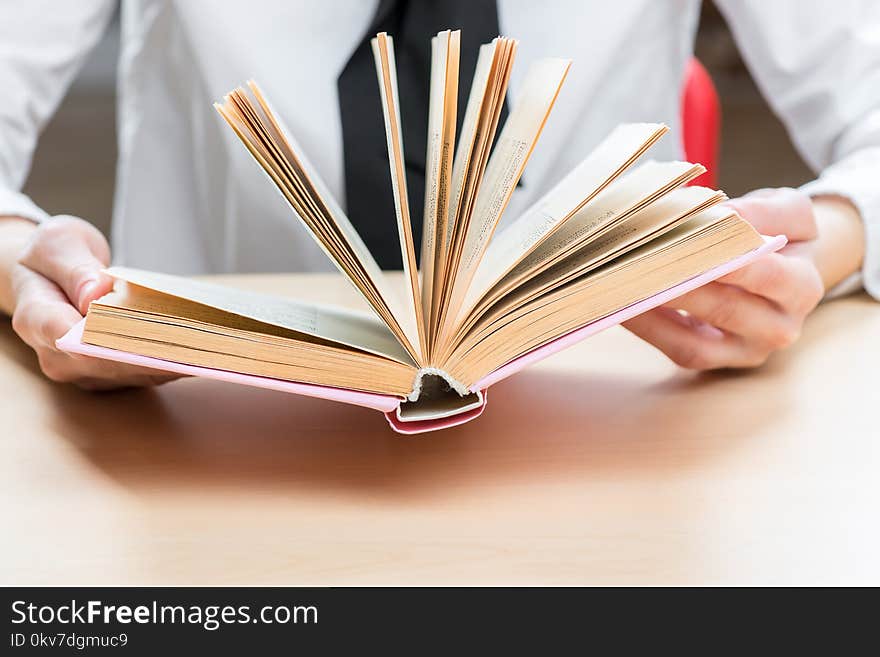 An open book an interesting novel in female hands closeup