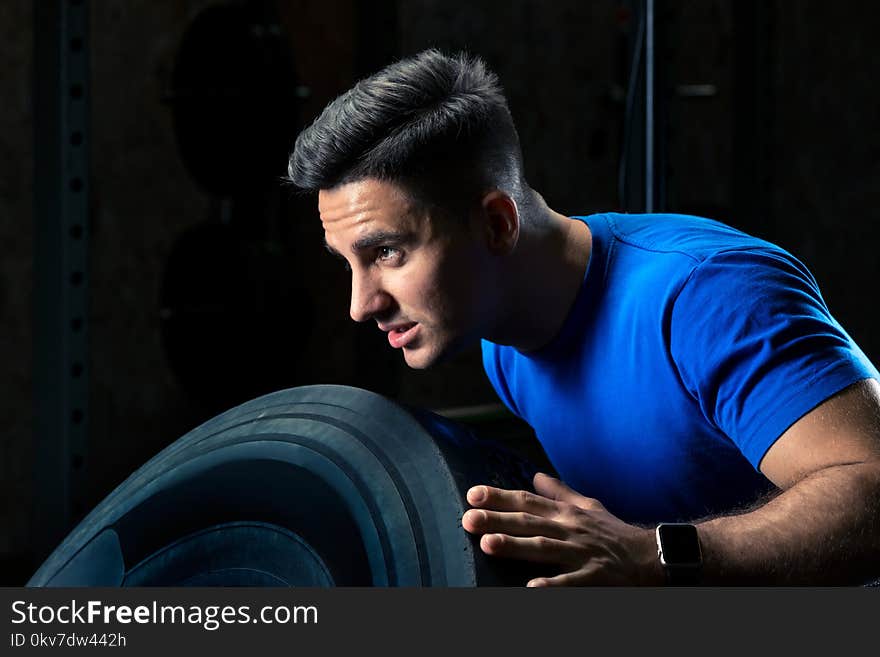 Close-up portrait of an athlete exercising with a wheel in the gym
