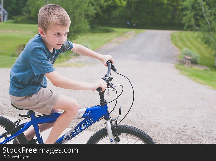 Boy Rides Blue Trek Bike at Daytime