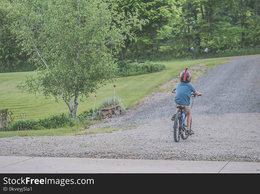 Boy Wearing Blue T-shirt and Beige Shorts Outfit Riding on Black Bicycle at Daytime