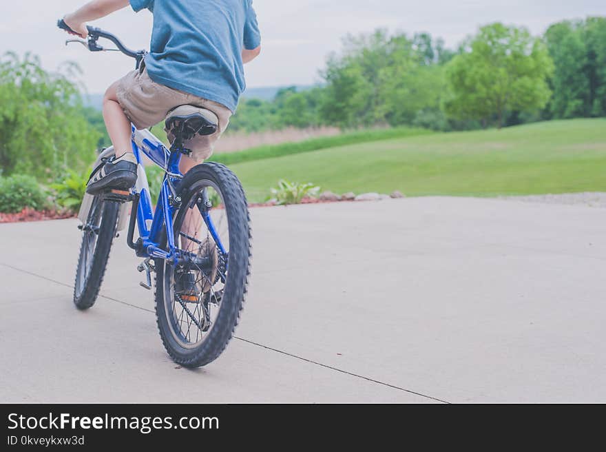 Person Riding Blue Bicycle