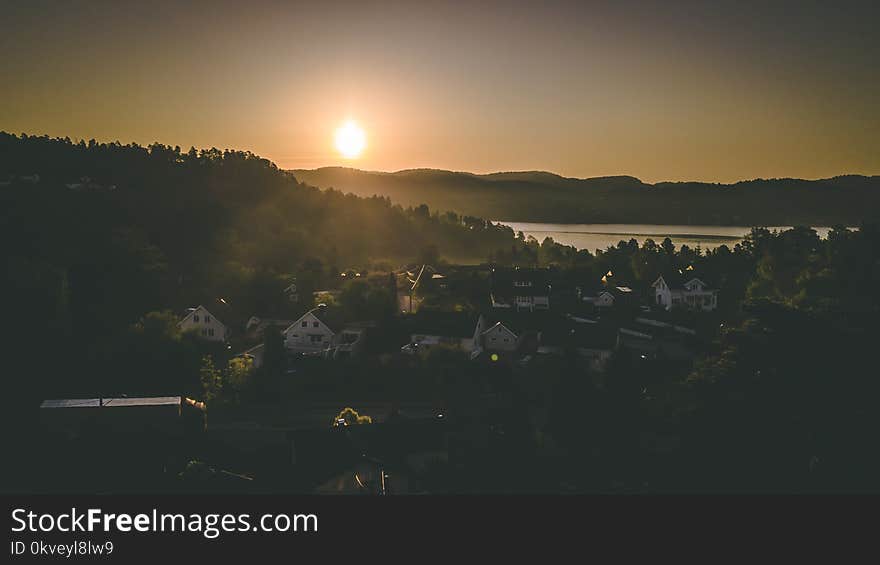 Village Near Mountain And Body Of Water