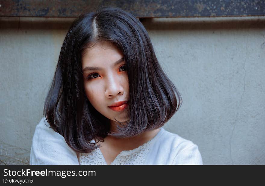 Woman in White Top Beside White Painted Wall