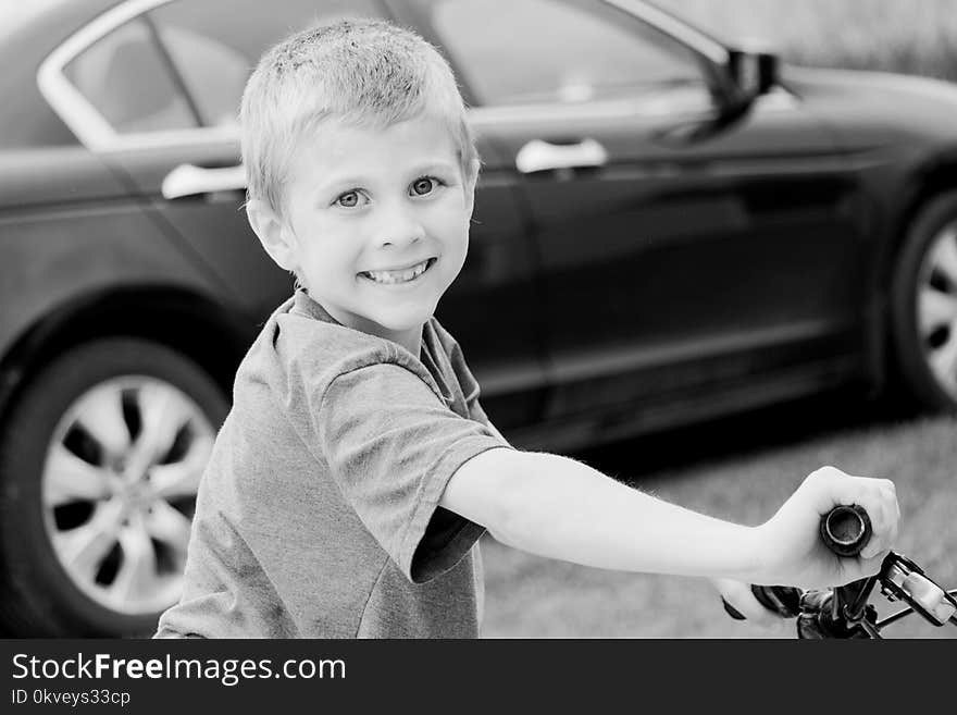 Grayscale Photo of Boy Riding Bicycle