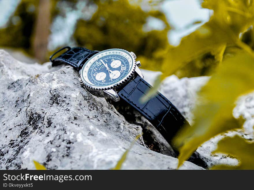 Selective Focus Photography of Chronograph Watch on Rock