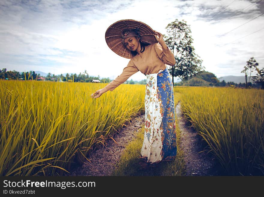 Woman Wearing Brown Long-sleeved Top And White And Blue Skirt Near Green Plants