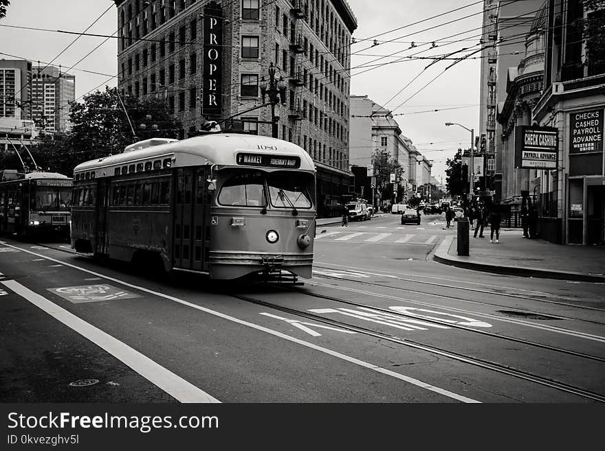 Grayscale Photography of Tram Near Buildings