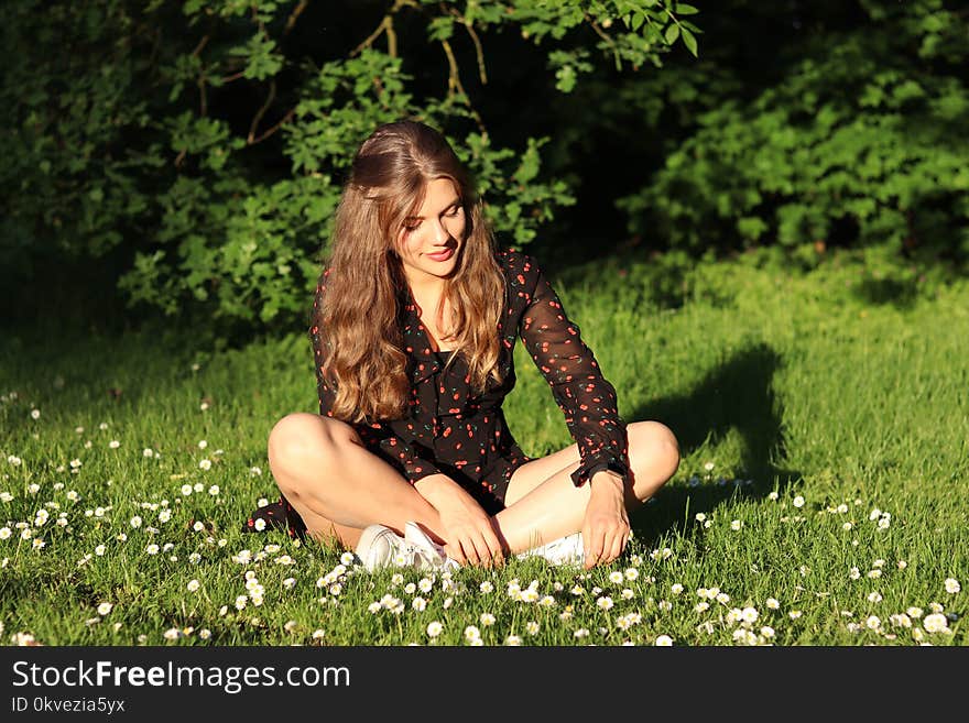 Woman Wearing Red and Brown Mesh Dress Shirt Sits on White Flower Field