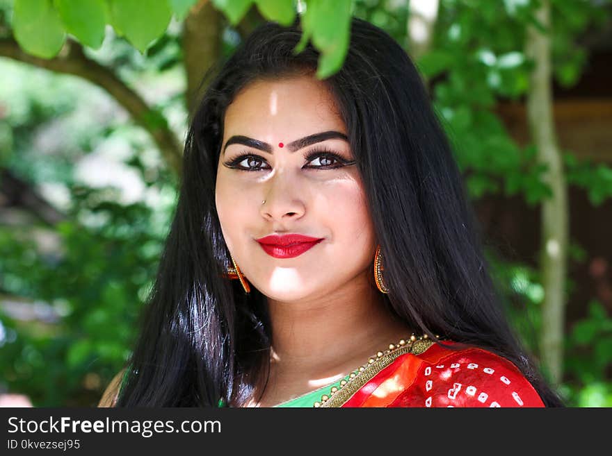 Woman Wears Red Top Under Green Tree at Daytime