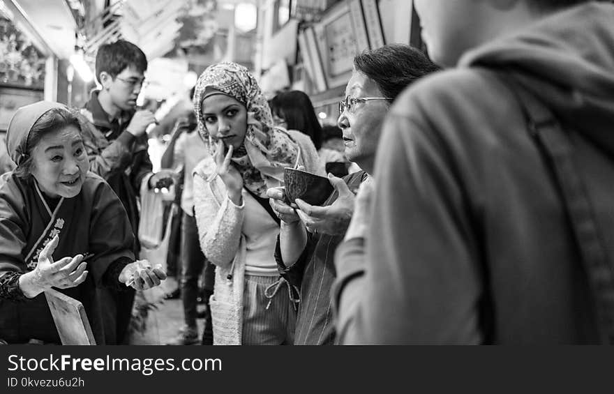 Greyscale Photo of People Outside