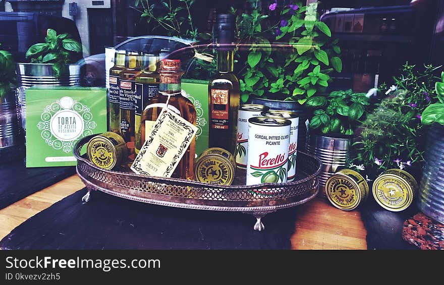 Photo of Bottles and Can on Tray Near Plants