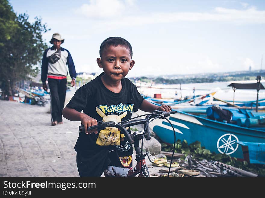 Boy Riding on Black Bicycle