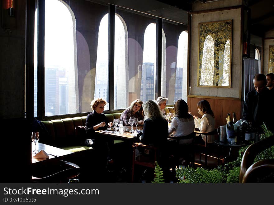 Group of People Sits Near Table