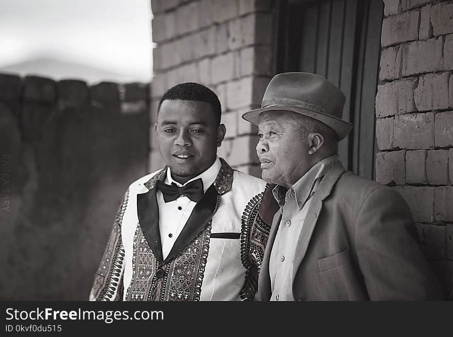 Gray Scale Photo of Two Men Wearing Coats