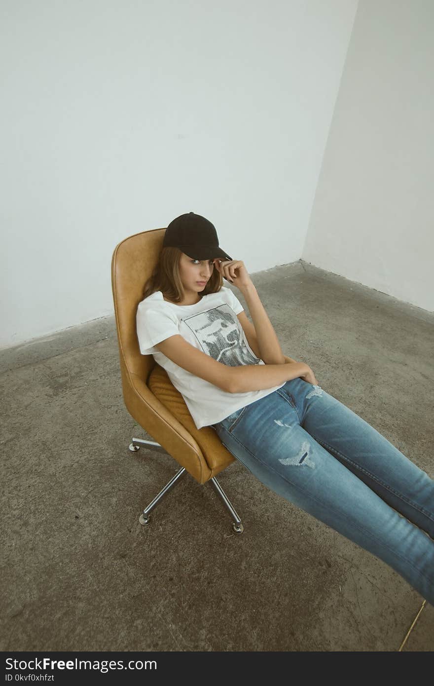 Woman Wearing White Printed Shirt Sitting on Brown Leather Rolling Chair