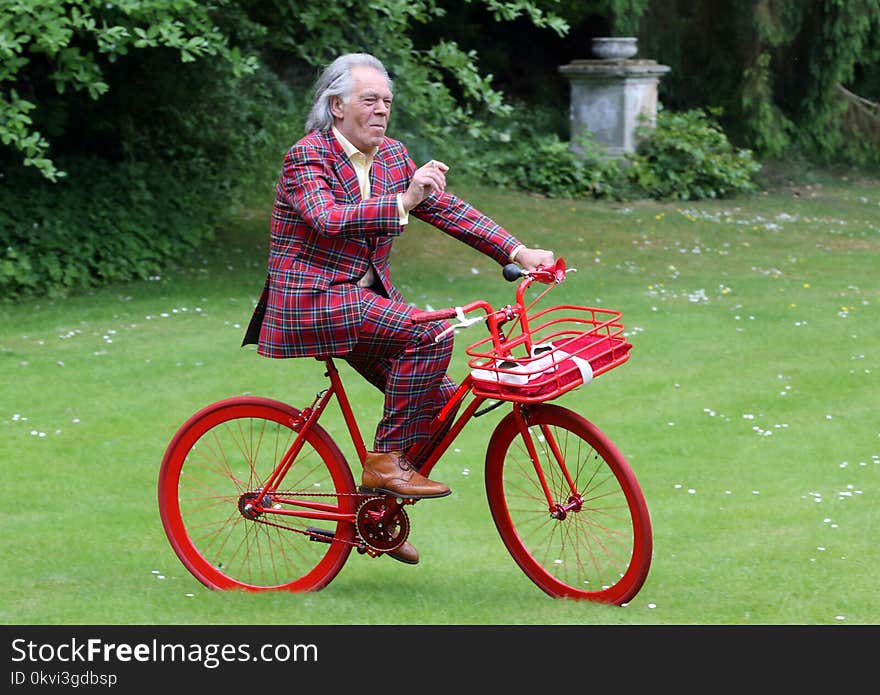 The bridegroom in a Scottish suit is looking forward to the red bike