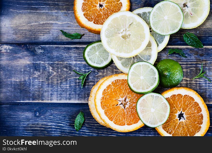 Artistic top view photo of different citruses - lemon, lime, orange - on rustic wooden background. Slices ripe fruits. Artistic top view photo of different citruses - lemon, lime, orange - on rustic wooden background. Slices ripe fruits.