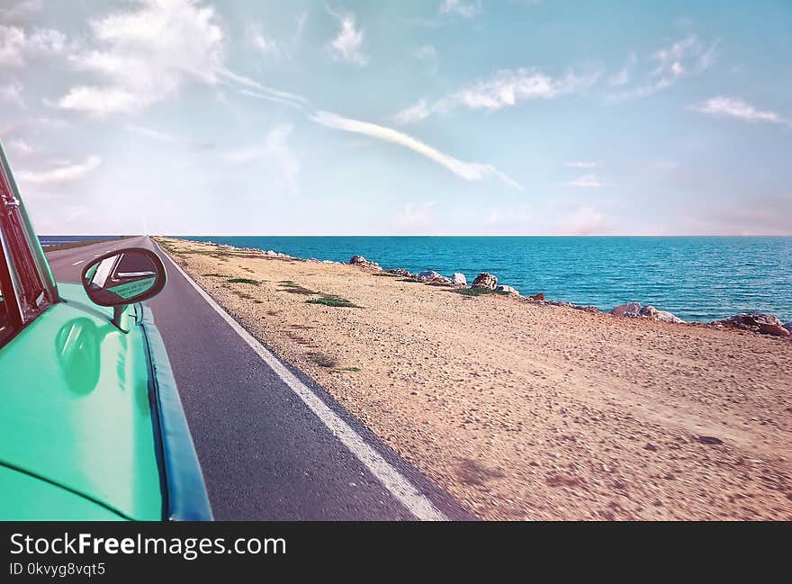 Green Car Near Seashore With Blue Ocean