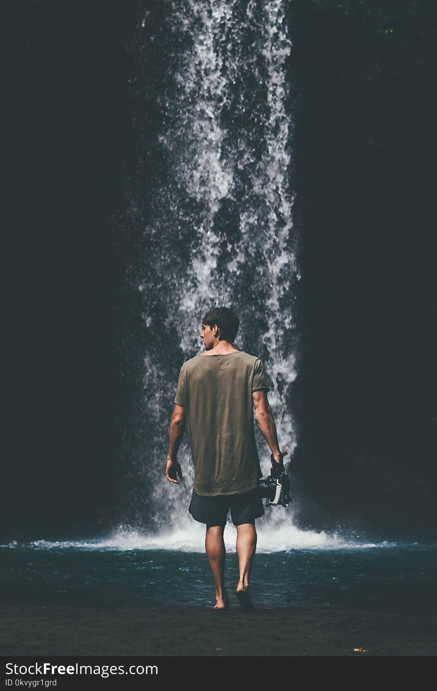 Man Wearing Gray Shirt Walking Near Waterfalls